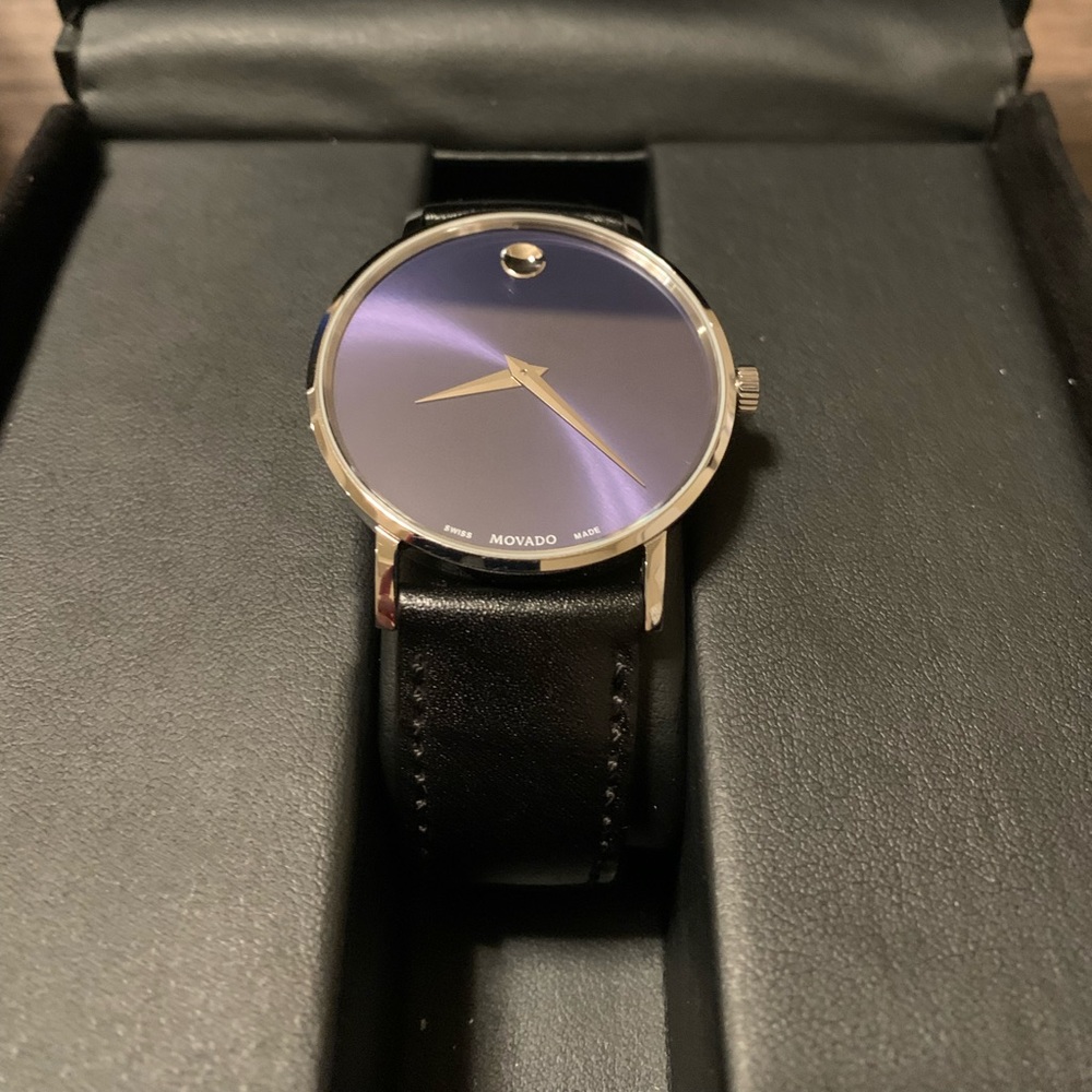 Movado Watch Silver and blue face with black leather band.